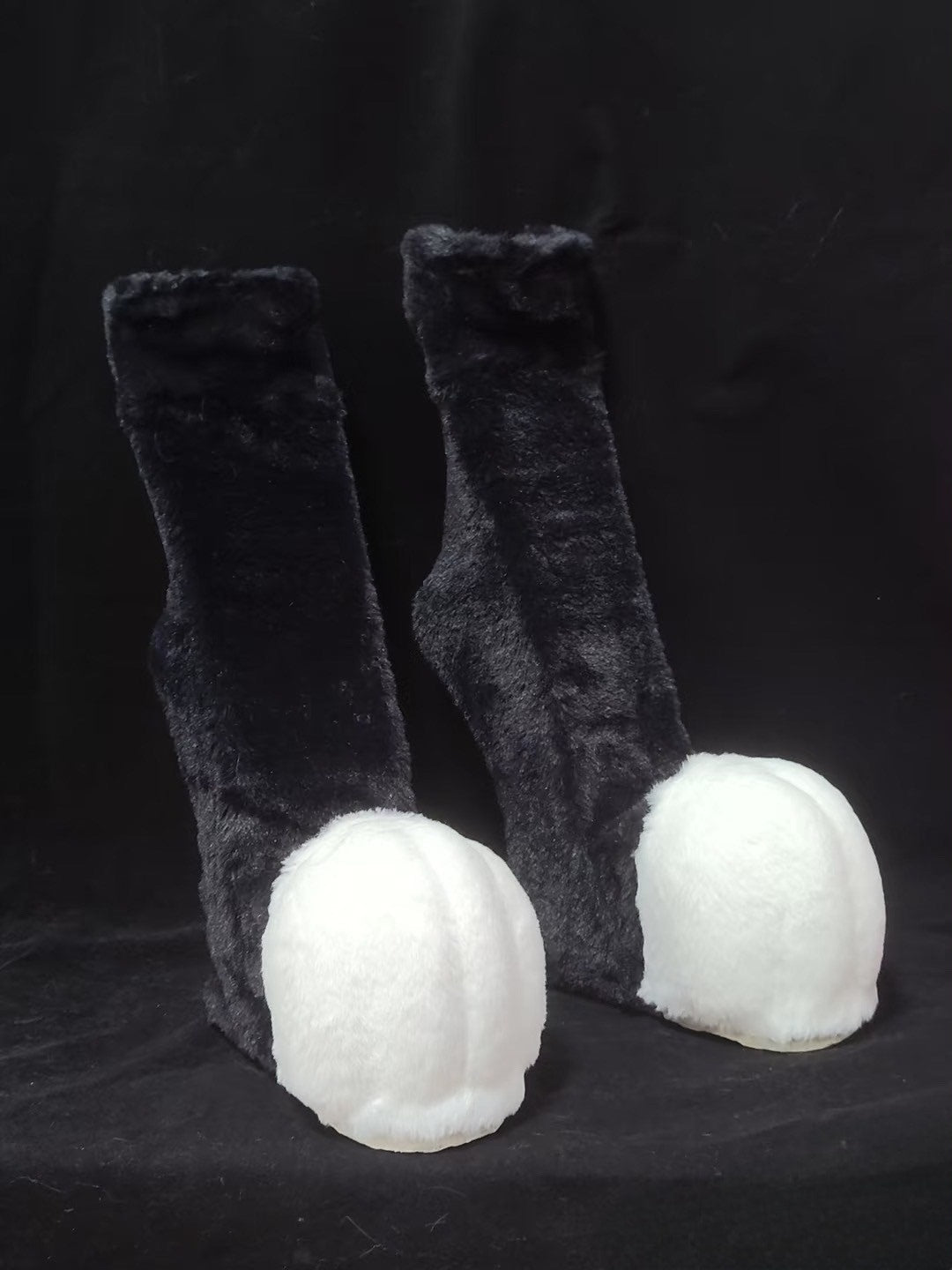 Furry black and white recurved legs and animal feet